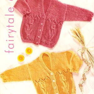 May include: Two knitted baby cardigans, one pink and one yellow, with a floral pattern. The cardigans are made with a delicate stitch and have a button closure. The pattern is called "fairytale doll" and the yarn is Patons.