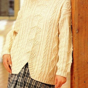 May include: A white cable knit sweater with a loose fit and a plaid skirt. The sweater has a textured design and is designed for larger sizes.