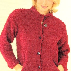 Può includere: Un cardigan rosso soffice con chiusura a bottoni e due tasche. Il cardigan è realizzato in un tessuto morbido e testurizzato.