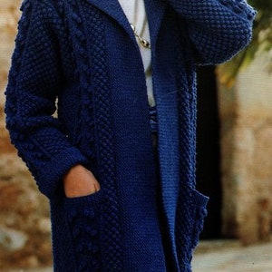 Op de afbeelding: Een lange, donkerblauwe gebreide cardigan met een kraag en zakken. De cardigan heeft een textuurpatroon en is open aan de voorkant.