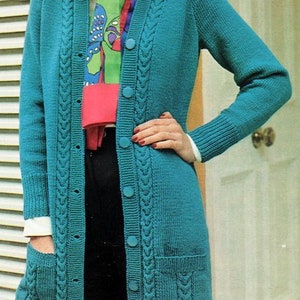 May include: A teal blue knitted cardigan with a cable knit pattern, long sleeves, and a button front. The cardigan has two patch pockets on the front and a white collar.