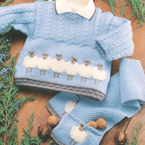 May include: A blue knitted baby sweater with a white collar and a row of sheep appliques. The sweater is paired with matching blue knitted booties with a sheep applique on each.