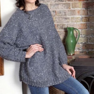 May include: A gray and white speckled sweater with a loose fit and long sleeves. The sweater is made of a soft, comfortable material.