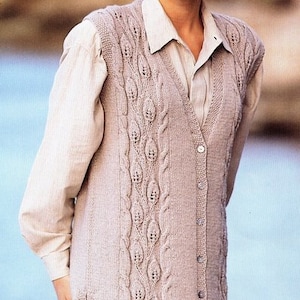 May include: A light beige knitted vest with a cable knit pattern and button closure. The vest has a V-neck and is sleeveless.