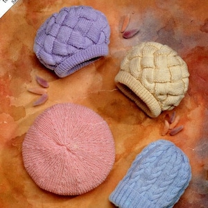 May include: Four knitted hats in different colors and patterns. The hats are made of a soft, textured yarn. The hats are arranged on a brown, textured surface.