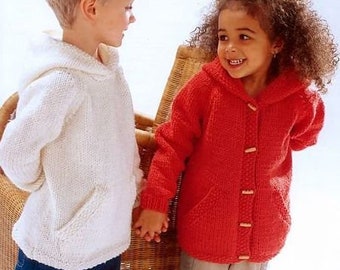 Op de afbeelding: Twee kinderen dragen gebreide hoodies. Het meisje draagt een rode trui en de jongen draagt een witte trui.