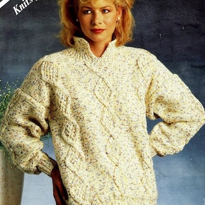 May include: Cream-colored chunky knit sweater with a cable knit design. The sweater has a high collar and long sleeves. The text on the image reads "Knits from 5 balls" and "CHUNKY 30-40 inch 76-102cm".
