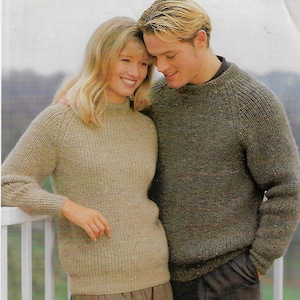 May include: A couple wearing matching knit jumpers. The woman's jumper is beige and the man's jumper is brown.