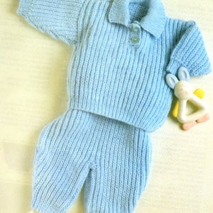 May include: A light blue knitted baby sweater and pants set with a collared neckline and button closure.
