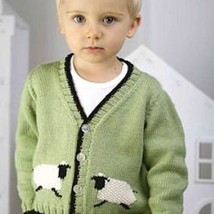 May include: A green knitted cardigan with black trim and two white sheep appliques on the front. The cardigan has a V-neck and buttons down the front.