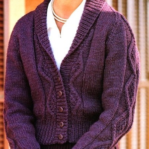 May include: A purple knitted cardigan with a shawl collar, button closure, and cable knit pattern.