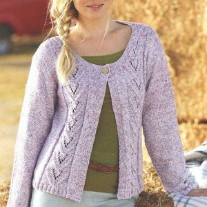 May include: A light purple cardigan with a delicate lace pattern and a button closure. The cardigan is made of a soft, textured yarn and has a relaxed fit.