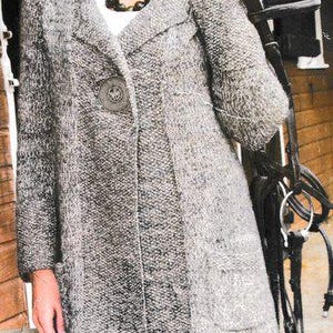 Könnte beinhalten: Ein grauer Tweedmantel mit großem Knopfverschluss und zwei Vordertaschen. Der knielange Mantel hat einen Reverskragen. Die Person trägt ein weißes Oberteil und eine dunkle Perlenkette. Der Mantel ist aus einem strukturierten Stoff.