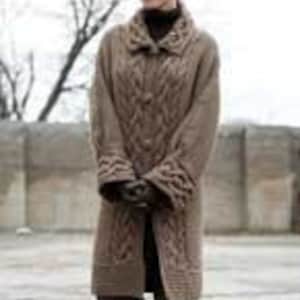 May include: A long, brown cable knit cardigan with a high collar and button closure. The cardigan has a textured pattern and is made of a soft, warm material.