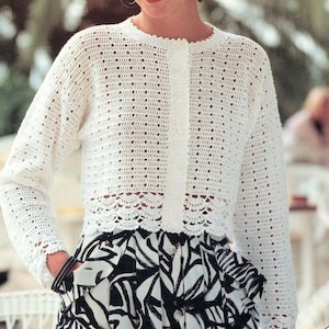 Puede incluir: Un cárdigan blanco de ganchillo con cierre de botón y un dobladillo festoneado. El cárdigan se lleva sobre una falda de estampado blanco y negro.