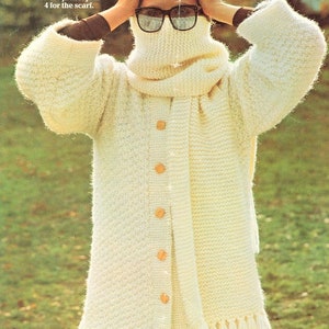 May include: A white knitted cardigan with a matching scarf. The cardigan has a round neck, button closure, and side vents. The scarf has a fringe trim. The text "PINGOUIN The best in hand knitting yarns" is visible at the bottom of the image.