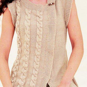 May include: A beige, sleeveless knitted vest with a cable knit design down the front. The vest has a round neckline and fastens with a wooden button. The garment is made of a soft, textured yarn.