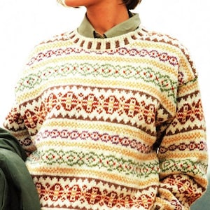 Op de afbeelding: Een crèmekleurige gebreide trui met een kleurrijk geometrisch patroon. De trui heeft een ronde hals en lange mouwen.