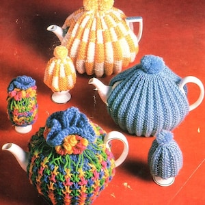 May include: Five knitted teapot cozies in various colors and patterns. The cozies are made with different stitches and textures, including stripes, ribbing, and bobbles. The cozies are all in different colors, including yellow, blue, green, and pink.