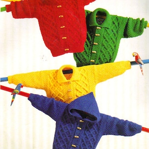 May include: Four knitted cardigans for children, hanging on a clothesline. The cardigans are in red, green, yellow, and blue. Each cardigan has a button closure and a cable knit pattern.
