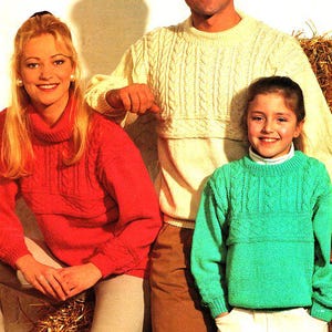 May include: Three people wearing knitted jumpers. The person on the left is wearing a red jumper, the person in the middle is wearing a cream jumper, and the person on the right is wearing a green jumper.