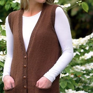 May include: A brown knitted waistcoat with a V-neck, button fastening, and two pockets. The waistcoat is being worn over a white shirt.