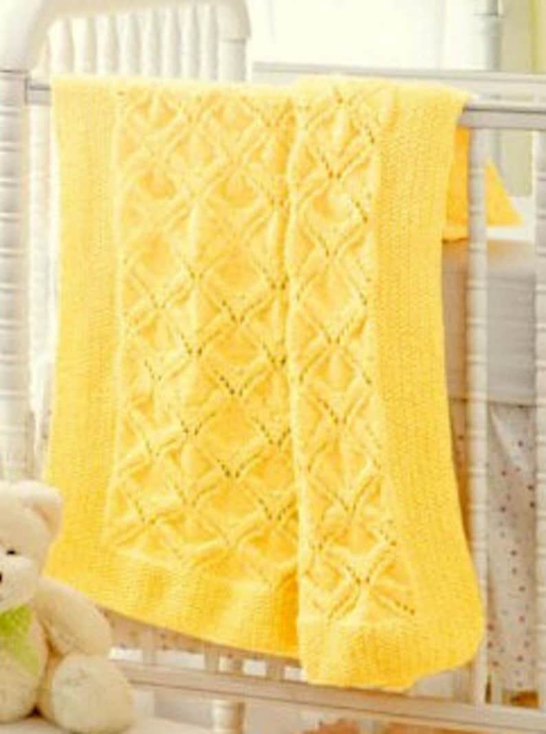Pode incluir: Um cobertor de beb&eacute; de malha amarela com um padr&atilde;o de diamante. O cobertor &eacute; macio e aconchegante, perfeito para o quarto de um beb&eacute;.