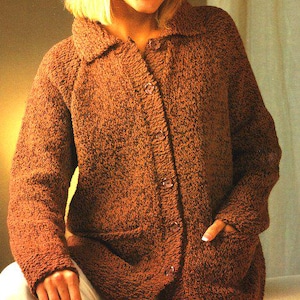 May include: A brown, textured knit cardigan with a collared neckline and button-up closure. The cardigan features two front pockets and is made of a thick, warm material. The buttons are a matching brown color.