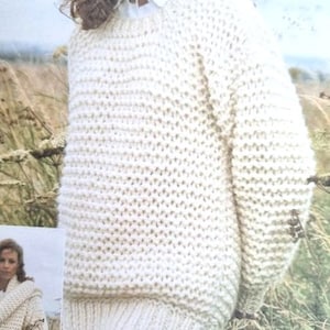 Peut inclure: Un pull en tricot blanc avec un col rond. Le pull est fait d'un fil doux et moelleux et a une coupe ample et ample.