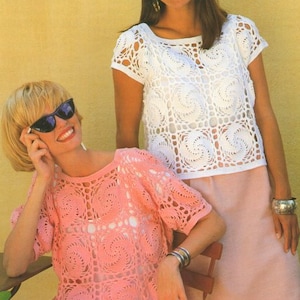 May include: Two women wearing crocheted tops. The woman on the left is wearing a pink top and the woman on the right is wearing a white top. Both tops have a square pattern with a circular design in the center of each square.