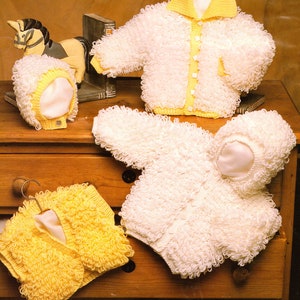May include: Four knitted baby jackets in white and yellow. Two jackets have hoods, one has a collar, and one is a cardigan. The jackets are made with a fluffy yarn.