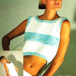May include: A white sleeveless top with blue and green stripes. The top is cropped and has a side slit. The model is wearing white pants.