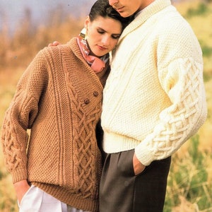 May include: Two knitted sweaters, one brown with a cable knit pattern and one cream with a cable knit pattern on the sleeves.
