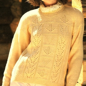 May include: A cream-colored knitted sweater with a delicate lace pattern. The sweater has a high neckline and long sleeves.