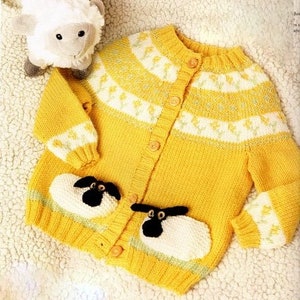 May include: A yellow knitted cardigan with a white and yellow floral pattern. The cardigan has a button closure and two pockets with embroidered sheep appliques.