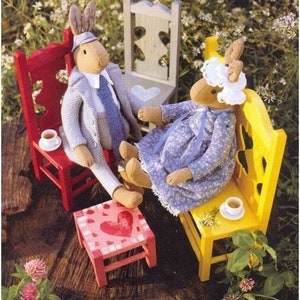 May include: Two plush toys, a rabbit and a deer, are sitting on miniature chairs. The rabbit is wearing a gray jacket and a blue tie. The deer is wearing a blue dress with a white lace collar. The chairs are painted in red, yellow, and white.