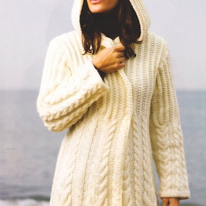 May include: A white knitted cardigan with a hood and cable knit detail. The cardigan is open at the front and has a long, flowing silhouette.