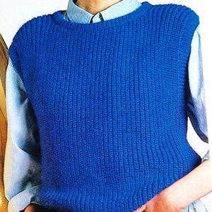 May include: A vibrant blue knitted vest with a ribbed texture. The vest is worn over a light blue collared shirt and paired with blue jeans. The overall style is casual and comfortable.