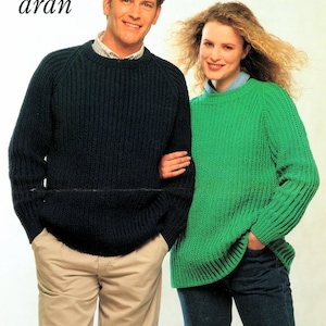 Op de afbeelding: Twee mensen dragen gebreide truien. De persoon links draagt een donkerblauwe trui en de persoon rechts draagt een groene trui.