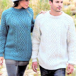 May include: Two people wearing cable knit sweaters. The sweater on the left is blue and the sweater on the right is white.