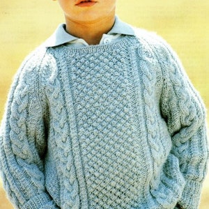 May include: A light blue knitted sweater with a cable knit pattern and a textured stitch design.