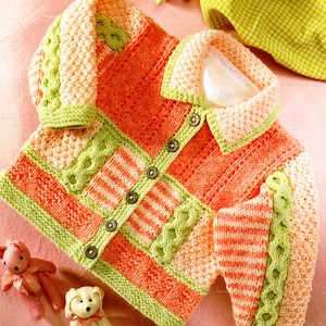 May include: A knitted baby cardigan in shades of peach, green, and white. The cardigan has a button fastening and a collar.