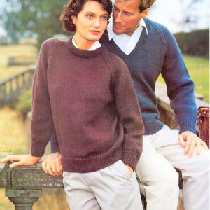May include: Two people wearing knitted jumpers. The person on the left is wearing a brown jumper with a round neckline. The person on the right is wearing a blue jumper with a V-neckline. The text "Pure Wool Superwash Sport" is at the top of the image.
