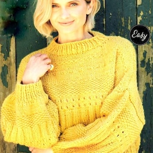 Könnte beinhalten: Ein gelber Strickpullover mit lockerer Passform und einem runden Ausschnitt. Der Pullover hat ein strukturiertes Muster und eine leicht verkürzte Länge.