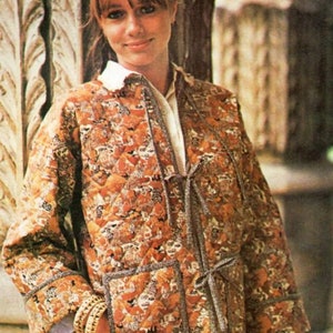 May include: A quilted jacket with a floral pattern in shades of brown, orange, and white. The jacket has a tie closure and a patch pocket on the front.