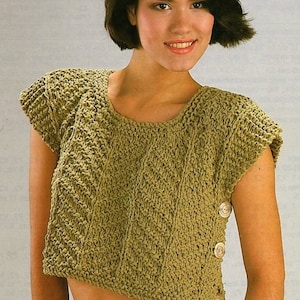 Può includere: Un top all'uncinetto verde con maniche corte e un dettaglio con bottone sul lato. Il top è corto e ha una vestibilità rilassata.