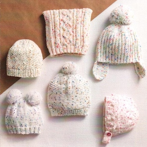 May include: A collection of six hand-knitted hats and a neck warmer in various styles. The hats are cream-colored with colorful flecks, some featuring pom-poms and ear flaps. The neck warmer has a cable knit design.