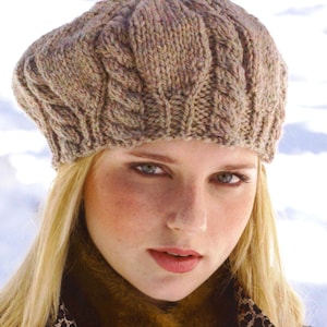 May include: A brown and beige knitted beret with a cable knit pattern. The beret is being worn by a person with blonde hair.