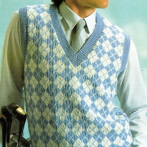 May include: A blue and white knitted waistcoat with a diamond pattern. The waistcoat has a V-neck and is worn over a white button-down shirt with a grey tie.