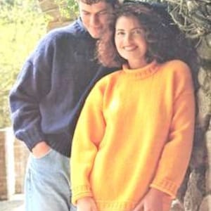 Puede incluir: Dos personas con suéteres, uno en un suéter azul marino y el otro en un suéter amarillo. La persona con el suéter amarillo está de pie junto a una pared de piedra.